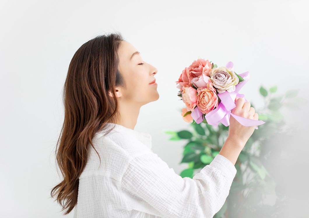 花の香りを嗅ぐ女性の画像