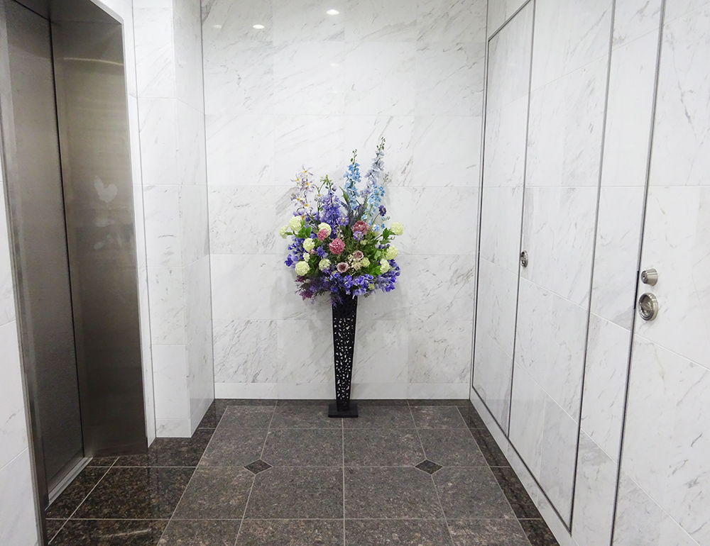 スイトピーとラナンキュラスとスノーボールの落ち着いた薄紫色のスタンド花