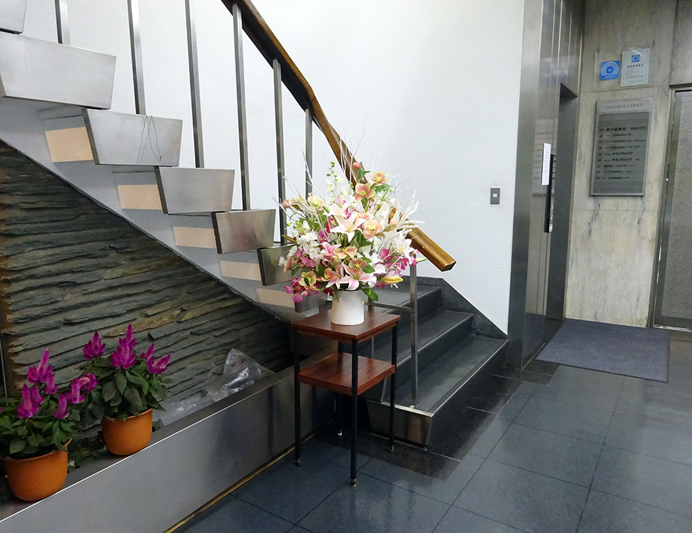 オフィスビルエントランスに飾られた造花アレンジメント